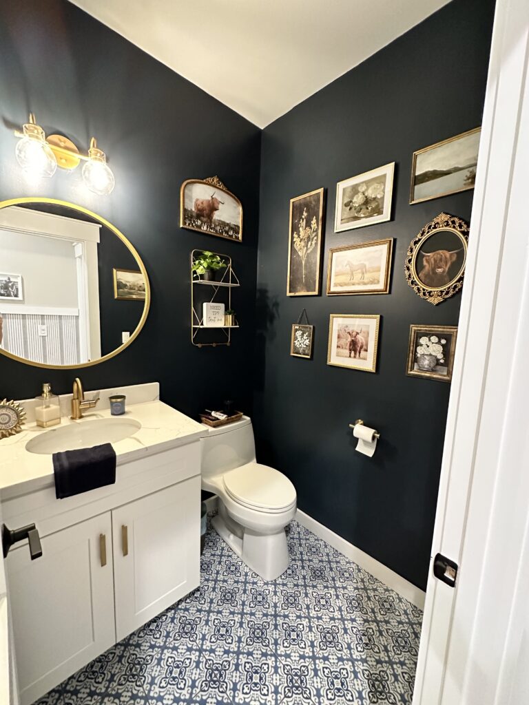 Beautiful moody blue bathroom; farmhouse refresh with gallery wall and gold accents