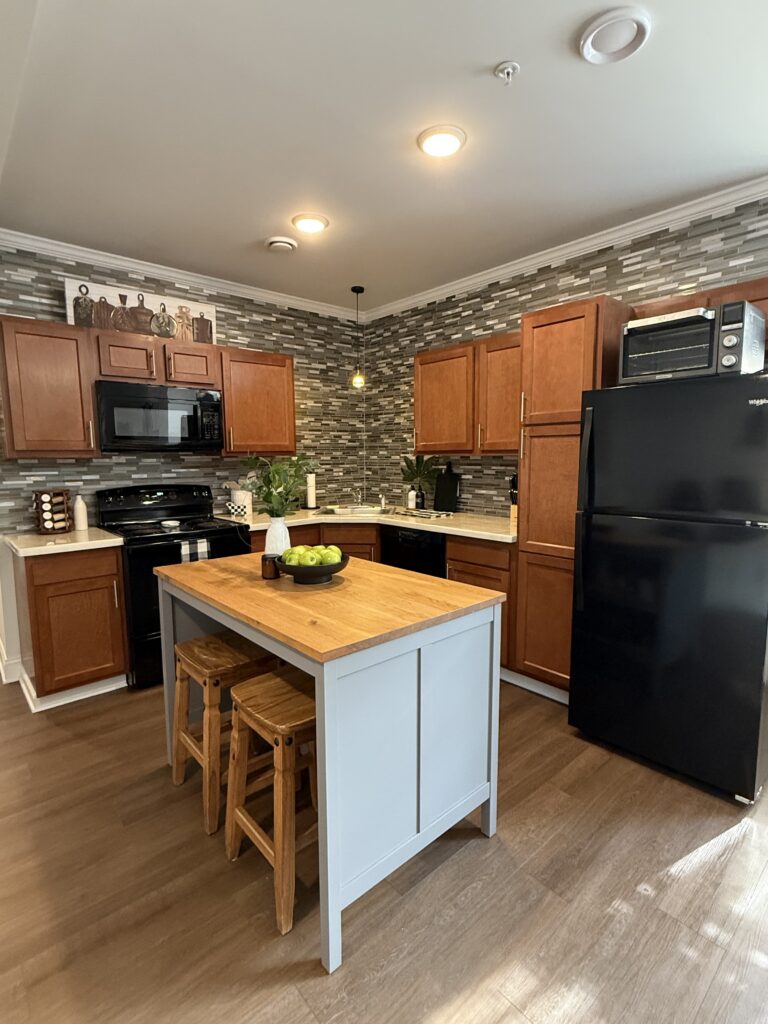 After shot of the kitchen, now styled with a cute center island and stools, some counter top and wall decor 
