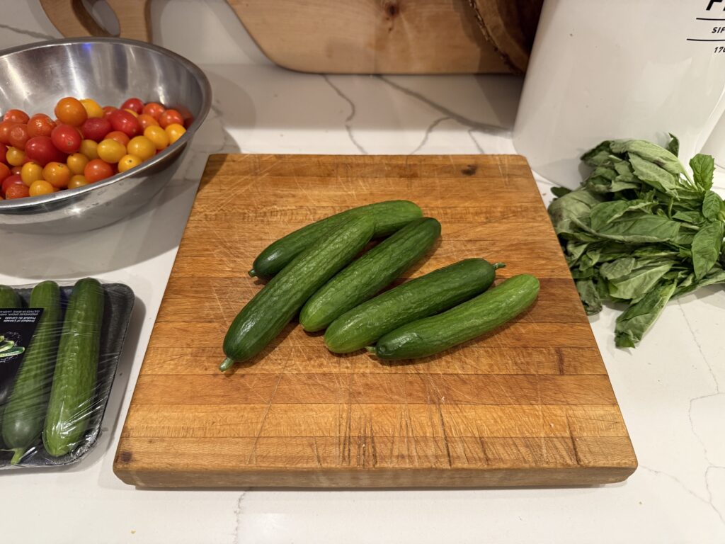 Mini cucumbers on a wooden cutting board prepared for homemad