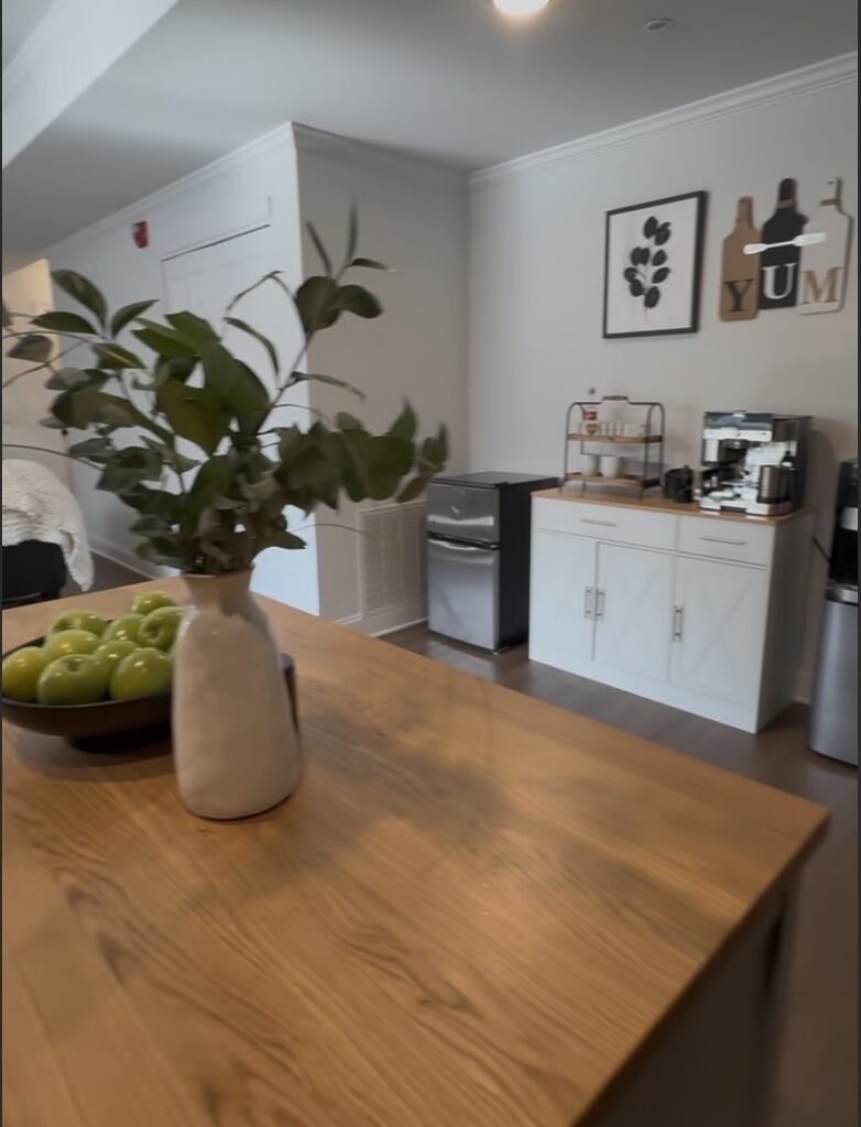After shot 2, overlooking the island in the kitchen and showing  the coffee bar with new white cabinet with wood top; cute coffee bar decor and functional espresso station with Ninja machine
