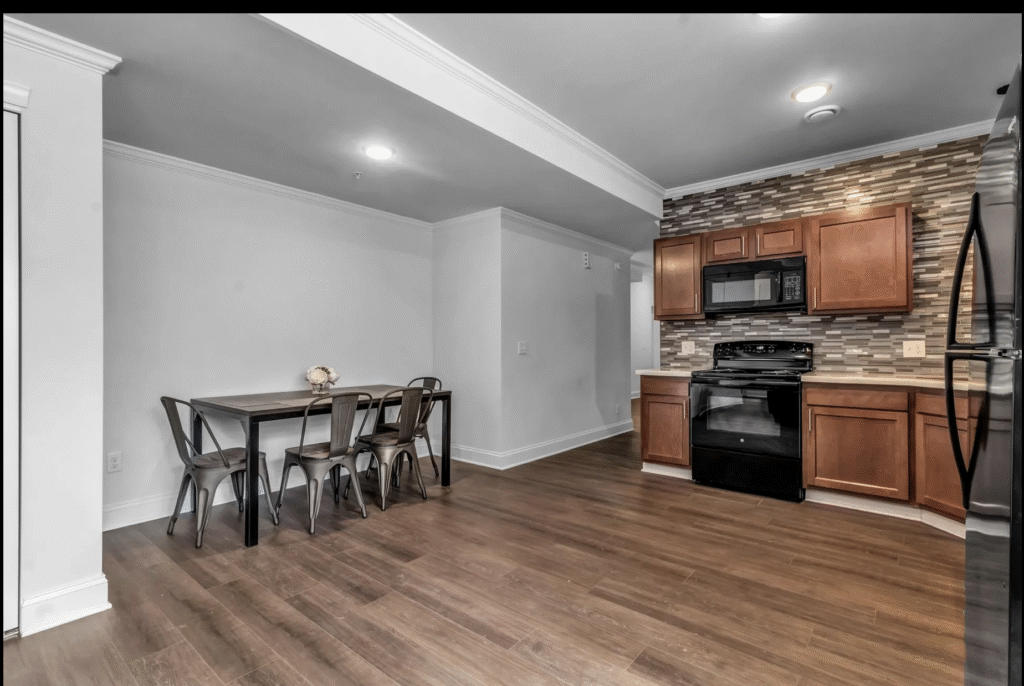Before shot of empty, bland kitchen with table and chairs in an awkward alcove 